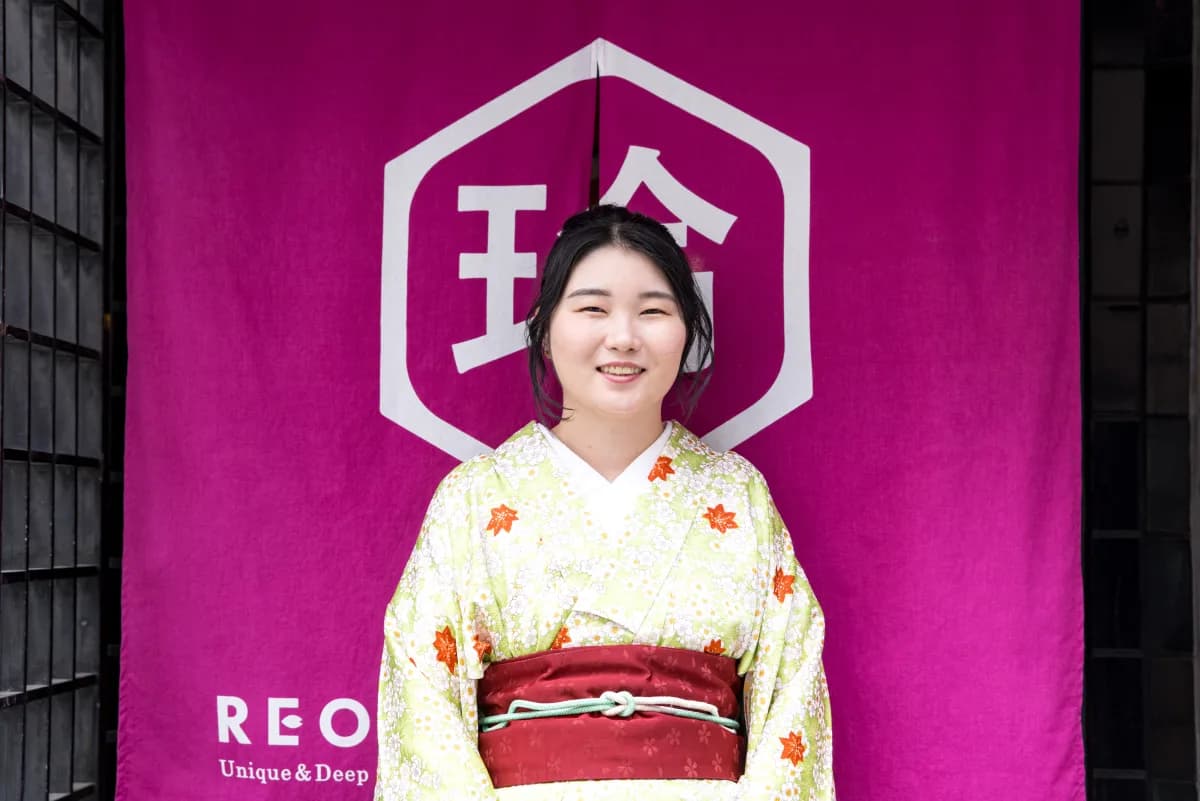Moemi, the host and English guide of REONA Sushi Tokyo, in front of the noren